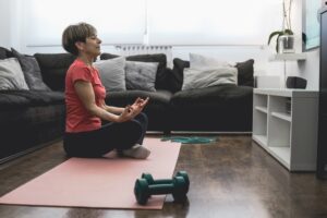 Senior woman doing online yoga sport workout class at home - Healthy and wellness elderly lifestyle